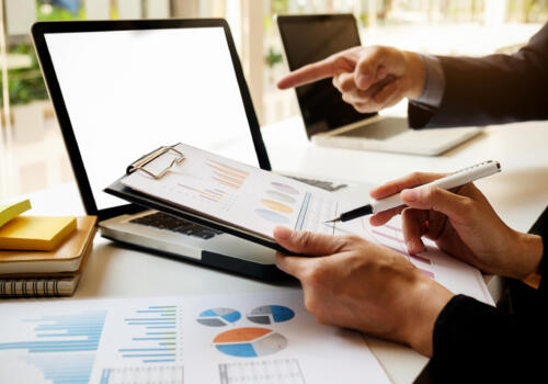 Business concept. Business people discussing the charts and graphs showing the results of their successful teamwork. Selective focus.